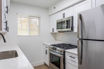 A kitchen with white cabinets and stainless steel appliances.